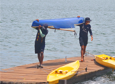 Two men carrying kayaks